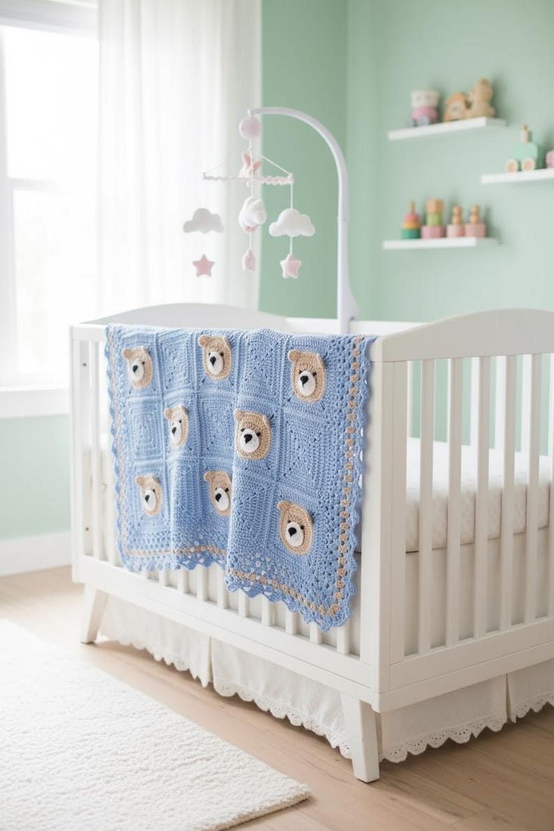 May include: A light blue crochet baby blanket featuring a repeating square pattern with beige and white bear face appliques. The blanket has a decorative scalloped border in blue and beige and is draped over the side of a white wooden crib.