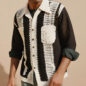 May include: A black and white crocheted long-sleeved shirt with a button-up front and a pocket on the left side.