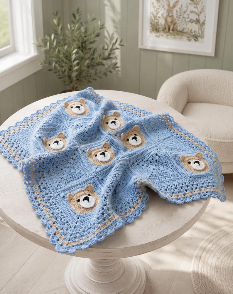 May include: A square crochet blanket featuring a repeating pattern of light blue squares and tan bear faces with white muzzles and black noses. The blanket has a decorative scalloped border in light blue and tan, constructed from yarn.