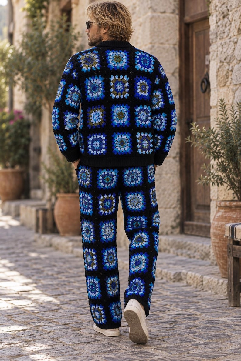 Puede incluir: Un conjunto de c&aacute;rdigan de manga larga y pantal&oacute;n de ganchillo con base negra y un patr&oacute;n repetitivo de cuadrados granny en tonos azul, azul claro y blanco. El c&aacute;rdigan cuenta con cuello y pu&ntilde;os acanalados en color negro, y el pantal&oacute;n es de corte recto.