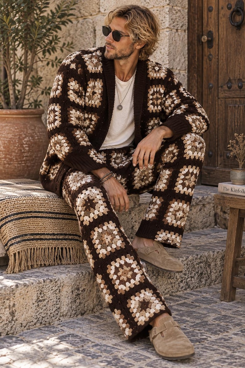 Puede incluir: Un conjunto de c&aacute;rdigan y pantal&oacute;n de ganchillo con un patr&oacute;n de cuadrados granny en tonos marr&oacute;n, beige y crema. El c&aacute;rdigan tiene cuello y pu&ntilde;os de canal&eacute; en marr&oacute;n oscuro, a juego con el pantal&oacute;n de corte recto.
