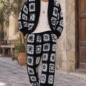 Puede incluir: Un conjunto de c&aacute;rdigan y pantal&oacute;n de ganchillo con un patr&oacute;n de cuadrados de la abuela en negro, gris y blanco. El c&aacute;rdigan tiene cuello de chal y cierre de botones, mientras que el pantal&oacute;n cuenta con cintura con cord&oacute;n y corte recto.