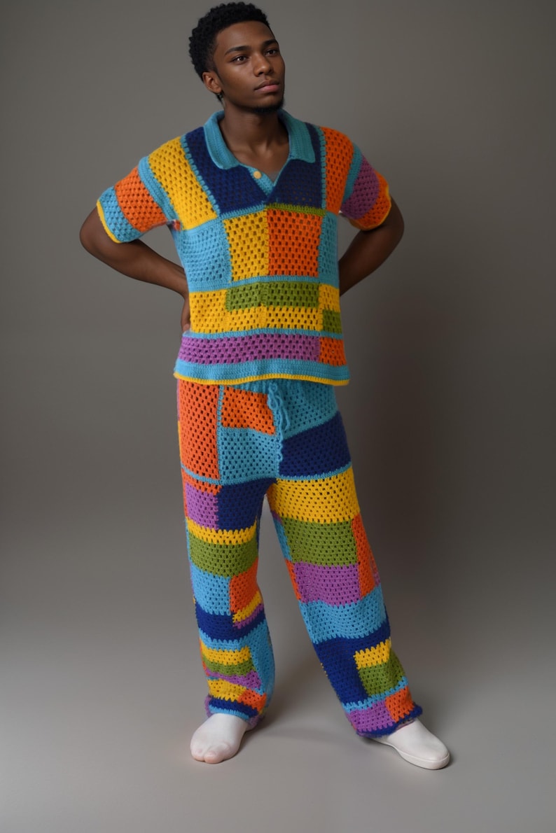 May include: A colourful crochet outfit with a short-sleeved shirt and trousers. The shirt and trousers are made of a patchwork of different coloured squares. The outfit is a bright mix of orange, yellow, green, blue, and purple.