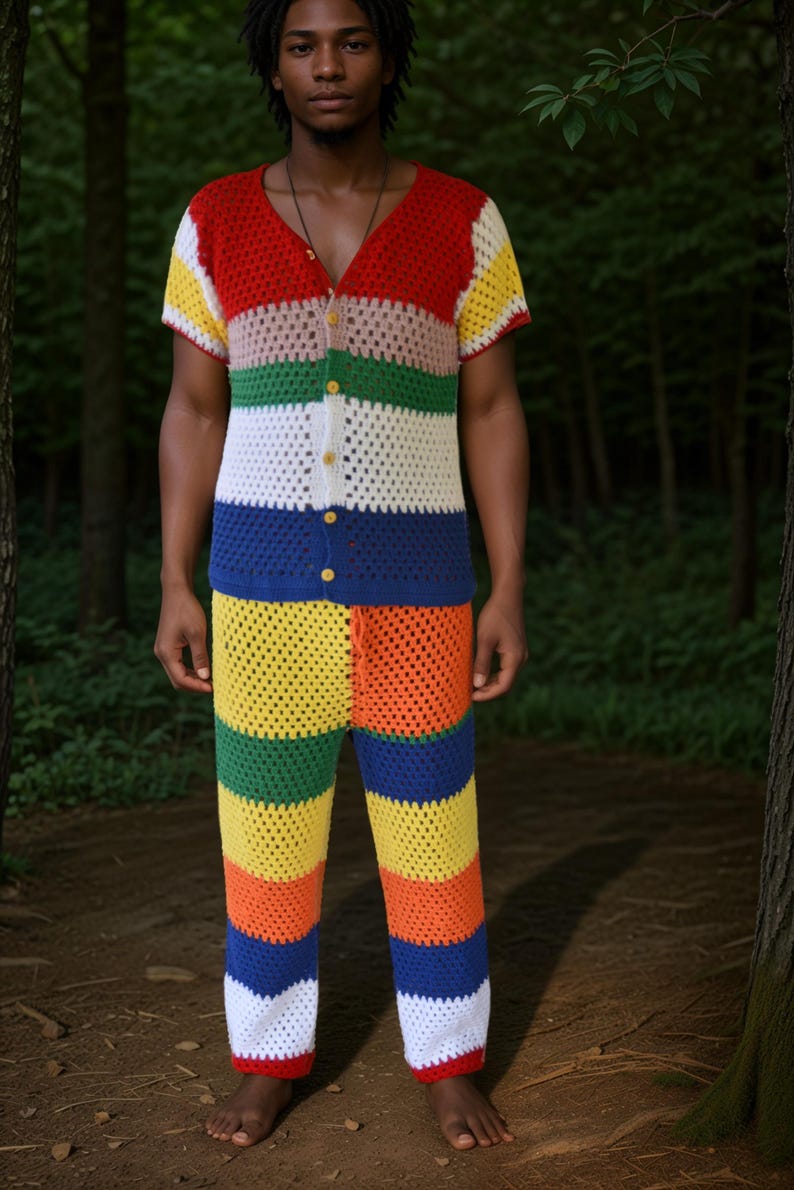 May include: A person wearing a multi-coloured crocheted shirt and trousers. The shirt and trousers are made of a thick yarn and have a striped pattern. The colours of the stripes are red, pink, green, white, blue, yellow, and orange.