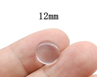 May include: A clear, round, 12mm diameter, glass cabochon.