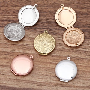 May include: Five round silver, gold, and rose gold locket pendants with a floral design on the front. The lockets are open to reveal a blank interior.