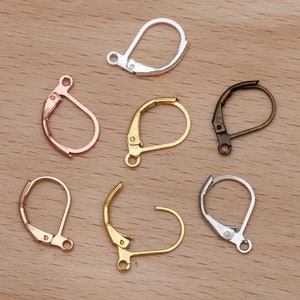 May include: Assortment of six earring hooks in different metal finishes: silver, gold, rose gold, and bronze. The hooks are all the same size and shape, with a small loop at the top for attaching earrings.