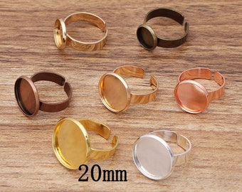 May include: Set of 7 adjustable ring blanks with 20mm round bezel settings in various metal finishes: gold, silver, bronze, copper, and rose gold.