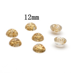 May include: Six 12mm round cabochons with gold flakes embedded in clear resin. The cabochons are arranged in a semi-circle on a white background.