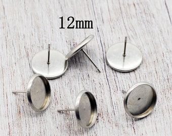 May include: Five silver-toned 12mm round earring blanks with a flat back and a post for attaching findings.