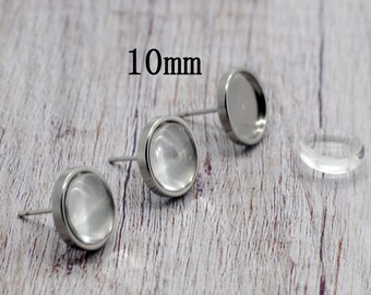 May include: Three silver earring settings with clear glass inserts. The settings are 10mm in diameter.  The text "10mm" is visible in the image.