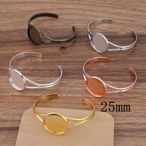 May include: Four different colored metal bracelets with a 25mm round glass bezel. The bracelets are silver, gold, bronze, and rose gold.