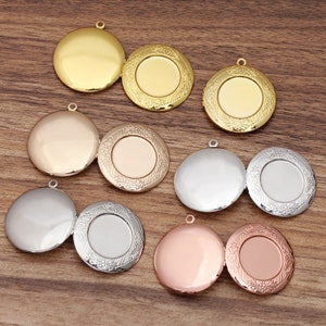 May include: Eight locket pendants in different colors, including gold, silver, rose gold, and copper. Each locket has a decorative floral design around the edge and a smooth, circular surface in the center.