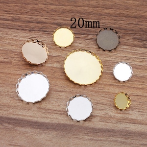 May include: Assortment of 20mm round metal tray settings with scalloped edges in silver, gold, and bronze.