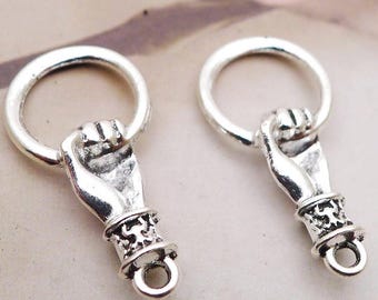 May include: Two silver-coloured charms, each featuring a hand clenching a ring. The hand is detailed with a cuff and a small loop at the base. The charms are likely for jewellery making or crafting.