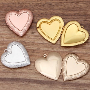 May include: Four heart-shaped locket pendants in different finishes: rose gold, gold, silver, and a combination of rose gold and gold. Each locket has a hinged opening and a delicate heart-shaped design.