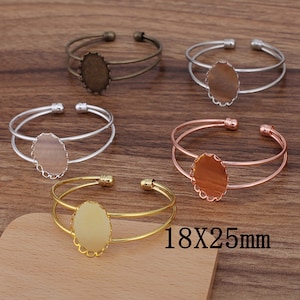 May include: Four different colored metal bracelets with a 18x25mm oval shaped bezel. The bracelets are made of silver, gold, rose gold, and bronze.