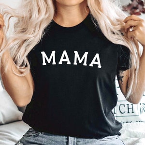 May include: A black t-shirt with the word "MAMA" printed in white on the front.