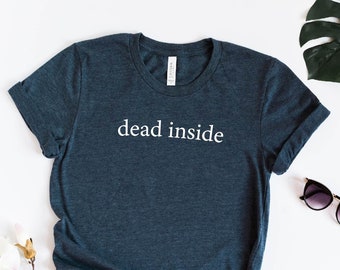 May include: A dark blue t-shirt with the text "dead inside" printed in white on the front. The shirt is made of a soft, comfortable material and has a relaxed fit.