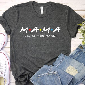 May include: A dark gray t-shirt with the text "M.A.M.A. I'll be there for you" in white. The "A"s are accented with red and yellow dots.