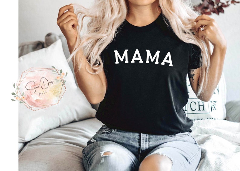 May include: A black t-shirt with the word "MAMA" printed in white on the front.