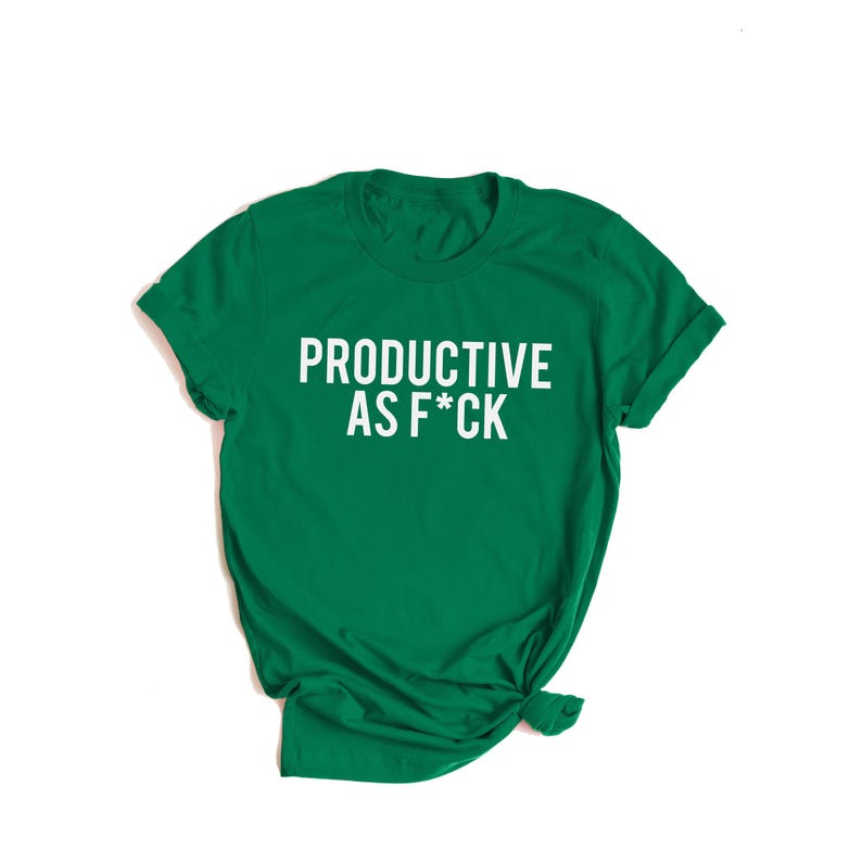 May include: A short-sleeved emerald green t-shirt featuring the white text "PRODUCTIVE AS F*CK" printed in a bold, sans-serif font across the center of the chest. The garment has a classic crew neckline and a standard fit with folded sleeves.