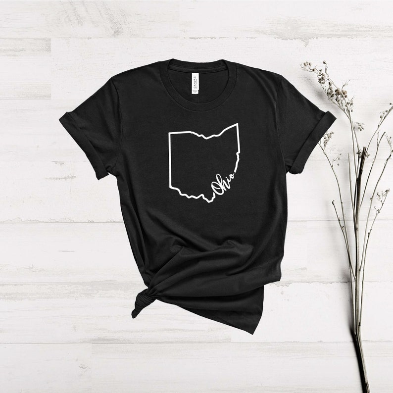 May include: Black t-shirt with a white outline of the state of Ohio and the word "Ohio" written in cursive.