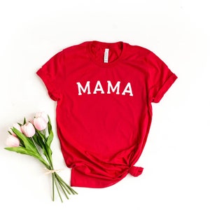 May include: Red t-shirt with the word "MAMA" printed in white on the front.