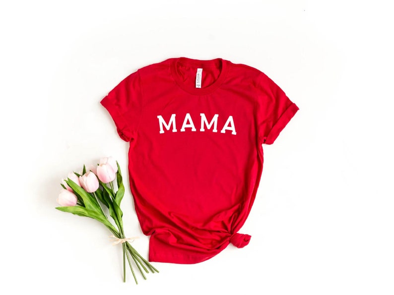 May include: Red t-shirt with the word "MAMA" printed in white on the front.