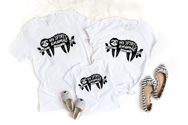 May include: Three white t-shirts with a black and white illustration of a sloth on a branch and the text "My Spirit Animal".