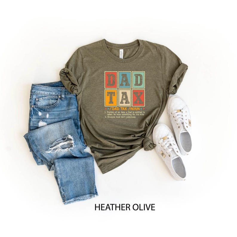 May include: A heather olive t-shirt with a vintage-style graphic that says "Dad Tax" and defines it as "Paying for an item a kid is entitled to, then he hopes nothing bad happens to his dad.  Promise you won't get punished."