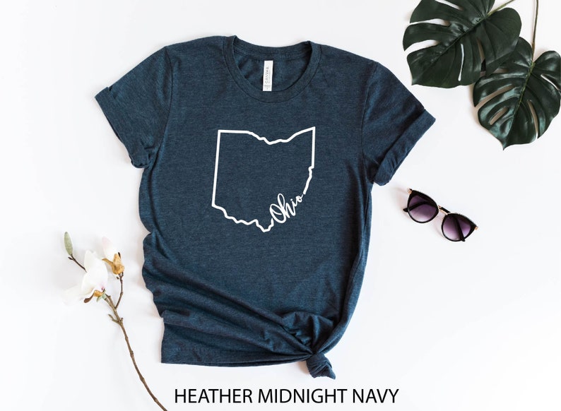 May include: A heather midnight navy t-shirt with a white outline of the state of Ohio and the word "Ohio" written inside the outline.