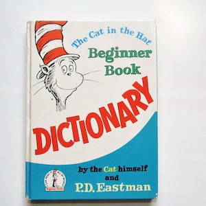 Könnte beinhalten: Ein Vintage-Buchcover mit dem Charakter Cat in the Hat aus der beliebten Kinderbuchreihe. Der Titel lautet "The Cat in the Hat Beginner Book Dictionary" von Cat selbst und P.D. Eastman.