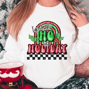 May include: White sweatshirt with a red and green graphic that says "I put the ho ho in holiday". The graphic features a rainbow and holly leaves.