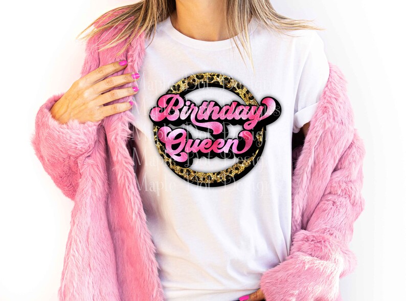 K&ouml;nnte beinhalten: Ein wei&szlig;es T-Shirt mit einer pinkfarbenen und schwarzen Grafik, auf der "Birthday Queen" in einem Kreis mit Leopardenmuster steht.
