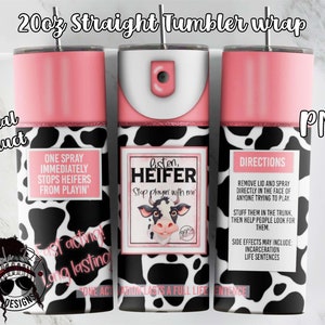 May include: A 20 oz. straight tumbler wrap with a cow print design. The wrap features a pink background with black and white cow spots. The text on the wrap reads "One spray immediately stops heifers from playin'" and "Listen, Heifer Stop playin' with me".