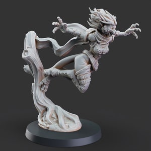 Puede incluir: Una figurita pintada de blanco de una criatura femenina con rasgos de lobo, que lleva una capa y sostiene un bastón. La figurita está posada en el aire, con una base en espiral.