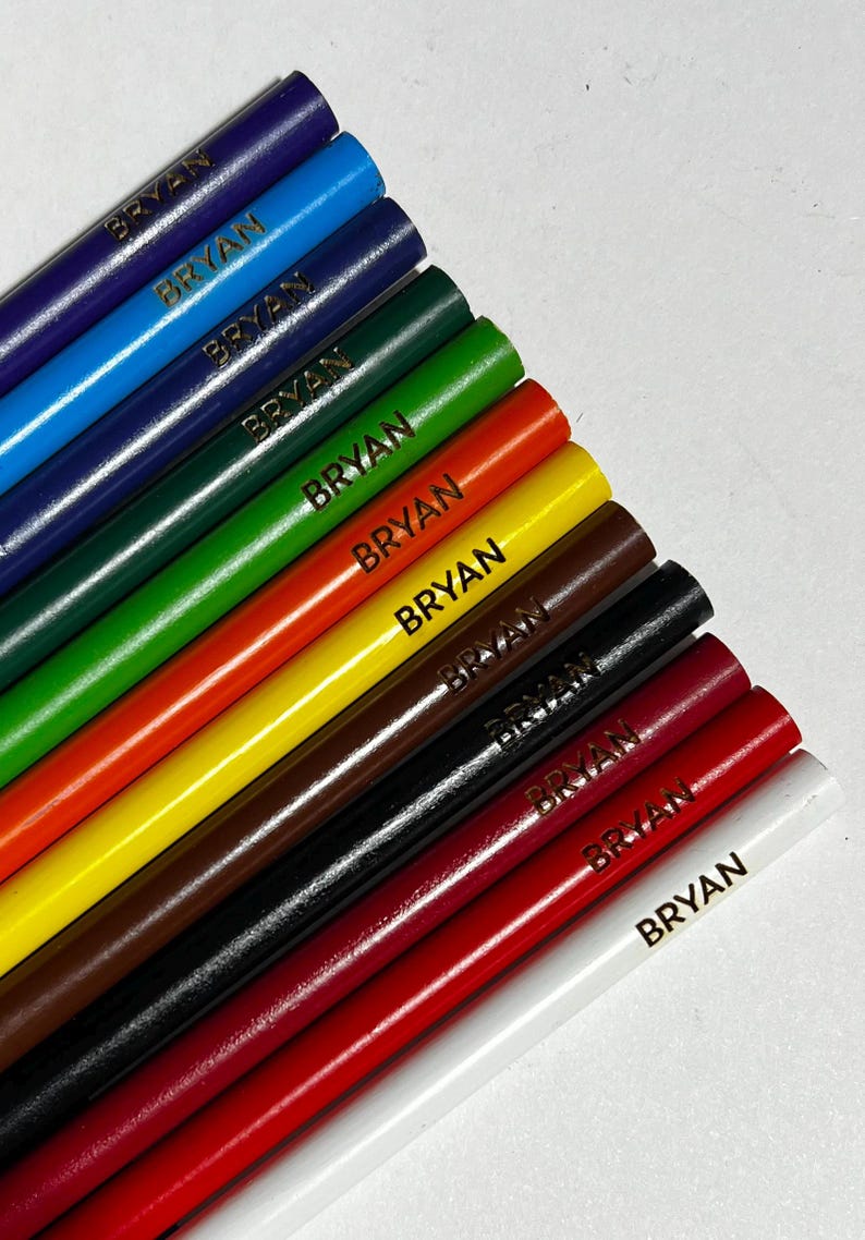 Puede incluir: Una colecci&oacute;n de diez l&aacute;pices de colores en varios tonos, incluyendo azul, verde, rojo y marr&oacute;n. Cada l&aacute;piz est&aacute; etiquetado con el nombre "BRYAN" en letras doradas. Los l&aacute;pices est&aacute;n dispuestos en diagonal, mostrando sus colores vibrantes.