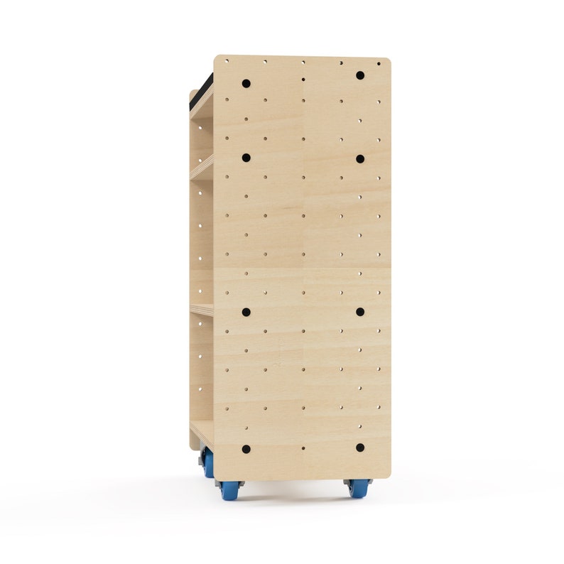 Puede incluir: Una estanter&iacute;a rodante de madera clara con cuatro estantes y una parte superior negra. Los estantes tienen agujeros para accesorios de tablero de clavijas. La unidad tiene cuatro ruedas azules.
