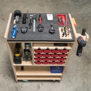 May include: A wooden tool cart with a variety of tools organized on top and in drawers. Tools include a tape measure, flashlight, digital caliper, pencil, timer, and a utility knife. The cart also has a drill and a router.