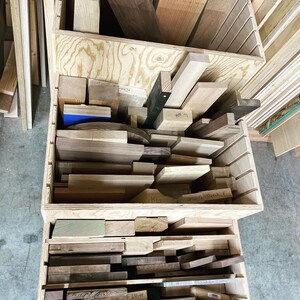 Puede incluir: Una caja de almacenamiento de madera con m&uacute;ltiples compartimentos llenos de varios tipos de madera. La caja est&aacute; etiquetada con los nombres de los diferentes tipos de madera, como "Maple" y "Walnut".