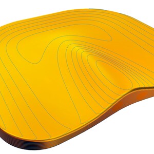Pu&ograve; includere: Un cuscino giallo sagomato con un design a strati. Il cuscino ha una superficie liscia e arrotondata e un centro leggermente incavato.