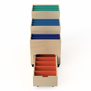 Puede incluir: Un organizador de archivos de madera con un caj&oacute;n extra&iacute;ble. El organizador tiene cuatro compartimentos con insertos de colores: verde azulado, azul, azul oscuro y naranja.