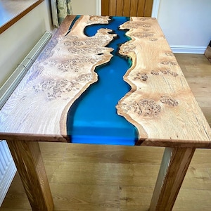 Burr Oak Dining table with a teal epoxy river and solid oak legs. *IN STOCK