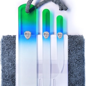 May include: Set of three glass nail files in a blue and green ombre design. The files are packaged with a gray washcloth and come with a hanging loop. The files are labeled "Gladzy Bohemian Beauty".