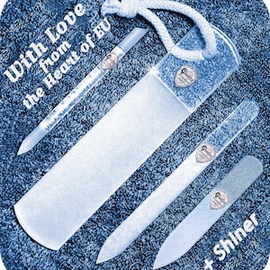 Puede incluir: Conjunto de cuatro limas de uñas de vidrio con un logotipo en forma de corazón que dice "Glaizy Professional Beauty". Las limas están sobre una toalla azul con el texto "With Love from the Heart of EU + Shiner".