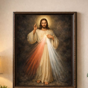 Puede incluir: Obra de arte religiosa enmarcada que representa una figura con pelo largo y un halo, vestida con una túnica blanca. La luz emana del pecho de la figura en rayos rojos y blancos. La obra de arte está en un marco marrón oscuro.