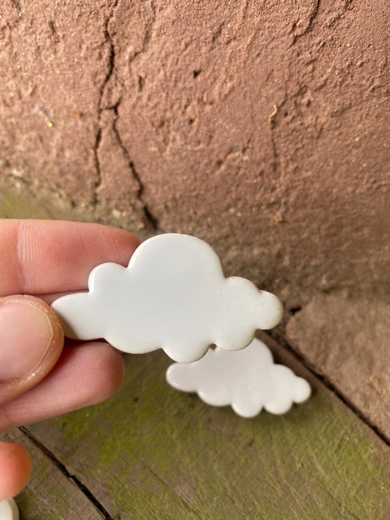 May include: A set of three white ceramic cloud shapes. The clouds are smooth and have a slightly rounded shape.