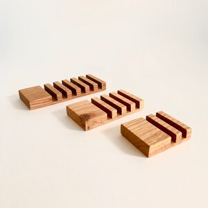 Puede incluir: Tres jaboneras de madera con diferentes n&uacute;meros de compartimentos. Las jaboneras son de madera marr&oacute;n claro y tienen un acabado natural.