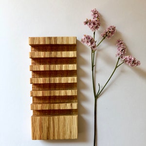 Puede incluir: Un jabonera de madera con cinco compartimentos, hecha de madera marr&oacute;n claro con un patr&oacute;n de veta natural. La jabonera est&aacute; sobre una superficie blanca.